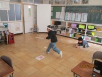 鬼役の児童が豆を当てられ逃げている様子